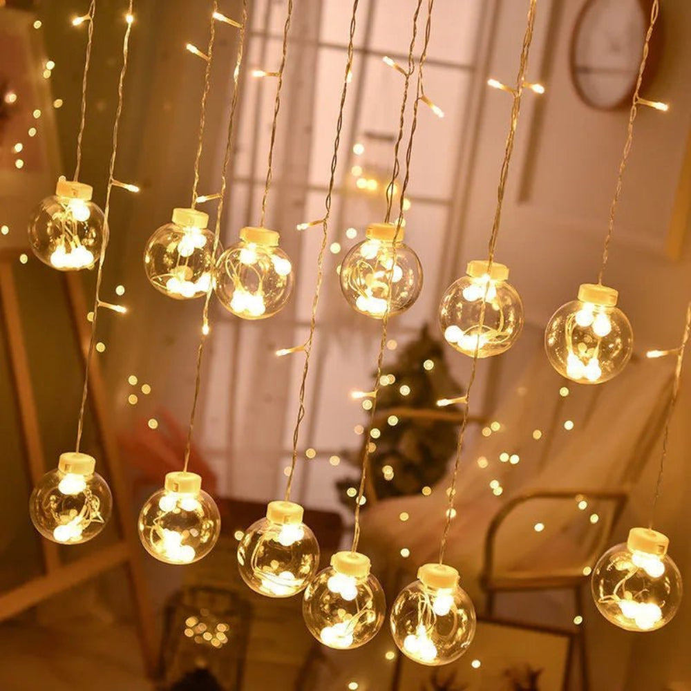 Leuchtvorhang mit hängenden Kugeln — warme und festliche Atmosphäre 